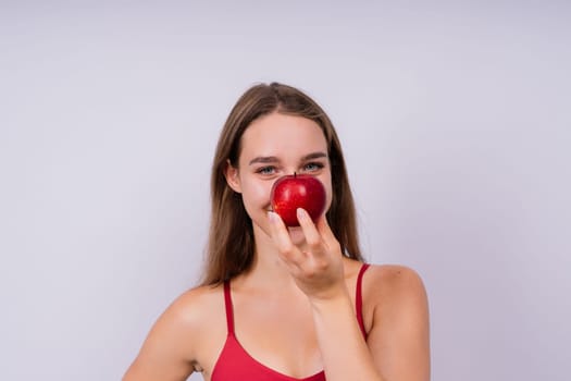 Morning breakfast. Woman with healthy teeth holding apples on a grey isolated background.