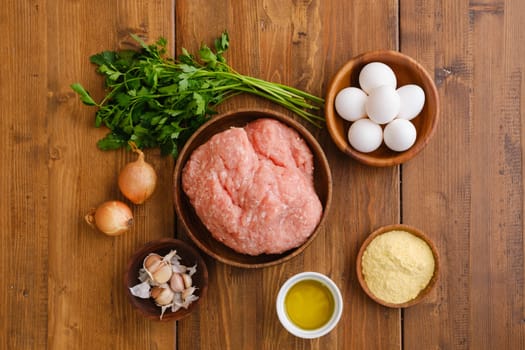 Top view of minced meat and ingredients for homemade meatballs on a table