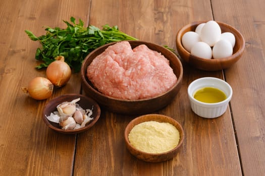 Overhead view of minced meat and ingredients for homemade meatballs on a table