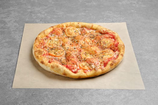 Classic pizza margherita with oregano on parchment