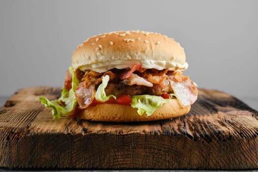 Beef chef hamburger with bacon on wooden background front view