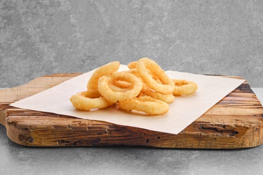 Deep fried spicy onion rings on parchment