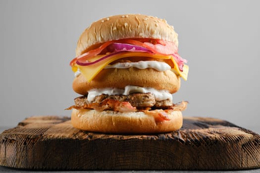 Monster double burger on wooden serving board, front view