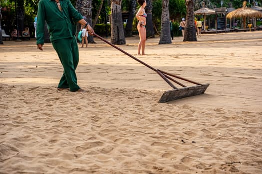 Smoothing the sand on the beach for beauty.