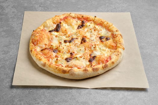 Pizza with different types of cheese on parchment paper