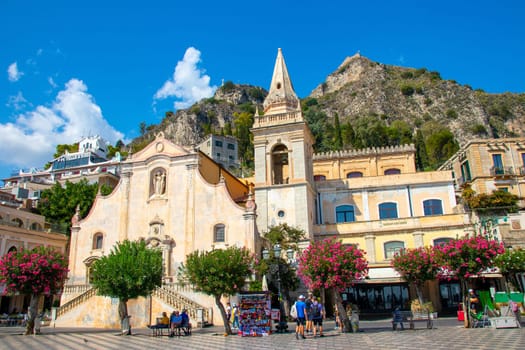 Sicily, Taormina, Italy - 28 September 2023. Tourists at Mainsquare Piazza IX Aprile and San Giuseppe church. City views, facades, architecture and the most popular streets.