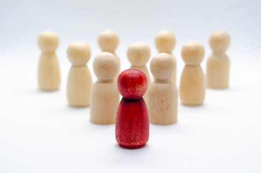 Leadership concept - red wooden figure leading other wooden figures reaching. Leadership concept.