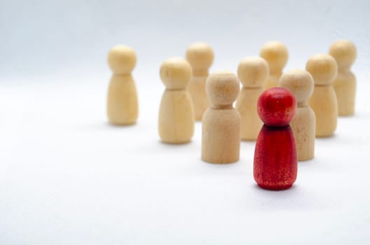 Leadership concept - red wooden figure leading other wooden figures reaching. Leadership concept.