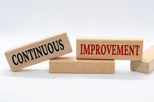 Continuous improvement text on wooden blocks. Business culture and Operational excellence concept.