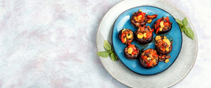 Mushroom caps baked stuffed with pepper and corn on rustic wooden background. Homemade food.