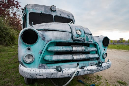 HENGELO, NETHERLANDS - MAY 2, 2023: Old and broken dodge ambulance car used as an art object