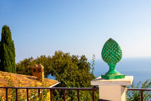 Sicily, Taormina, Italy - 28 September 2023. Selective focus on a green ceramic pine cone. The cones are a symbol of health, vitality and renewal and are placed on walls, balconies and next to gates.