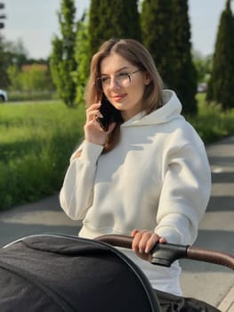 young pretty woman with straight long hair and wearing white sportswear walks with baby.