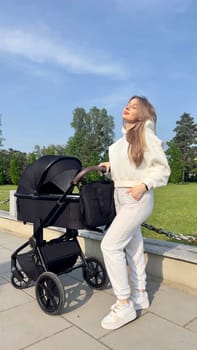 young pretty woman with straight long hair and wearing white sportswear walks with baby.