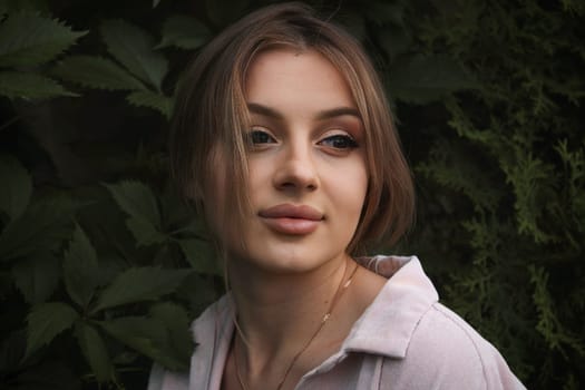 A cute girl on a dark background looks to the side.