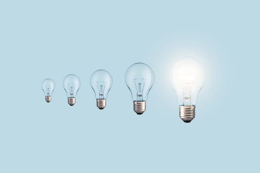 Creative light bulbs loading process and one glowing light bulb on a blue background. Creative idea, concept. Uploading a new idea. Project and success