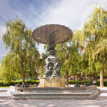 Stockholm, Sweden - June 26 2022: Swan statue at the Molin's Fountain in Kungstradgarden, The fountain is surrounded by lush green trees, creating a serene and peaceful scene
