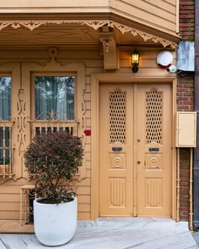 Exterior facade of residential building with walls painted in beige, decorated door, and wrought iron window, at a narrow street, Uskudar district, Istanbul, Turkey