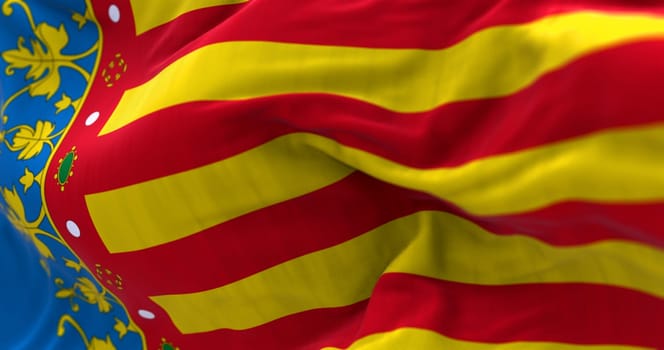 Valencian Community flag waving. Autonomous community of Spain. Four red bars on yellow, blue strip next to hoist. 3d illustration render. Selective focus. Close-up. Fluttering fabric