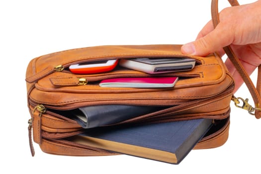 Leather handbag isolated. One hand holds a spacious brown luxury leather wrist bag. Fashionable businessman's bag or briefcase. Clipping Path.