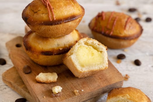 Pasticciotto leccese pastry filled with egg custard cream, typical sweet from Lecce, Italy. Pieces of pasticiotto on a wooden board, apulian breakfast, top view