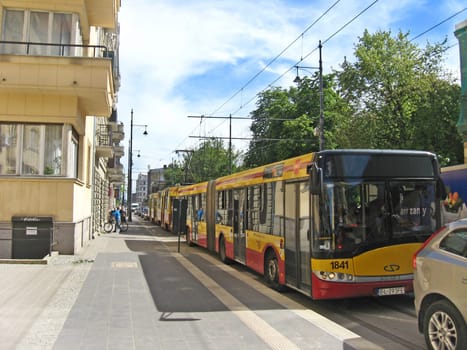 Bus going on street of Lodz. Urban transport. Buses at stop. Transporting passengers in city. Modern passenger transportation