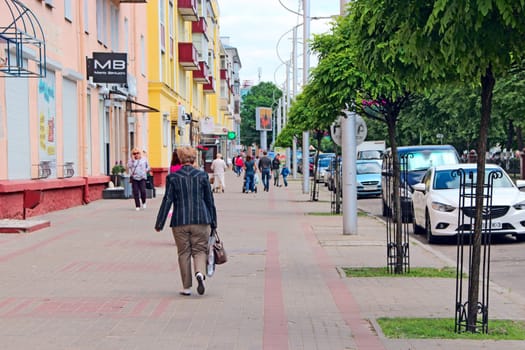 Central street of Gomel. People walking along Gomel street. Urban panorama. People walking along street of Belarusian city. Cityscape. Urban panorama