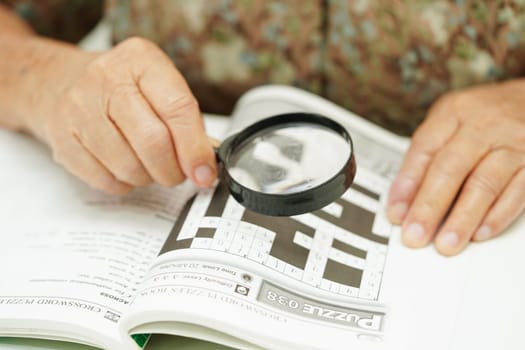 Bangkok, Thailand - May 15, 2022 elderly woman playing sudoku puzzle game for treatment dementia prevention and Alzheimer disease.