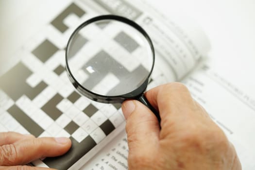 elderly woman playing sudoku puzzle game for treatment dementia prevention and Alzheimer disease.