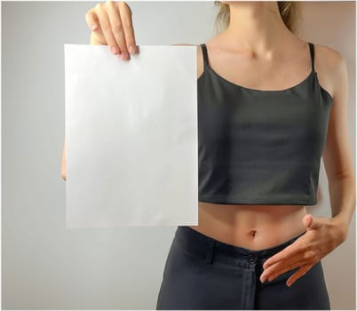 a young girl holds a white sheet of paper in her hands