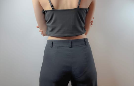 a young girl in black jeans and a black top is standing with her back to us