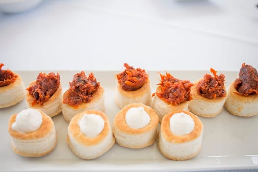 Puff pastry canapes with red Iberian chorizo and Torta del Casar cheese. Spanish cuisine