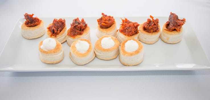 Puff pastry canapes with red Iberian chorizo and Torta del Casar cheese. Spanish cuisine