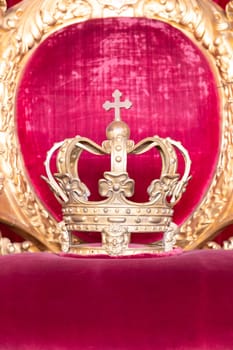 Ancient crown on red velvet. Antique symbol of authority, luxury, monarchy, nobility, success