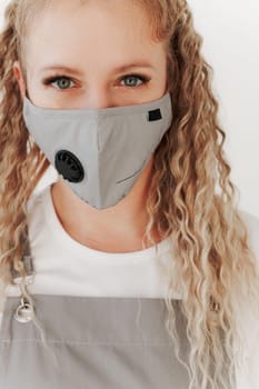 Close up portrait of Caucasian middle-aged woman in working uniform mask and apron looking at camera. White background