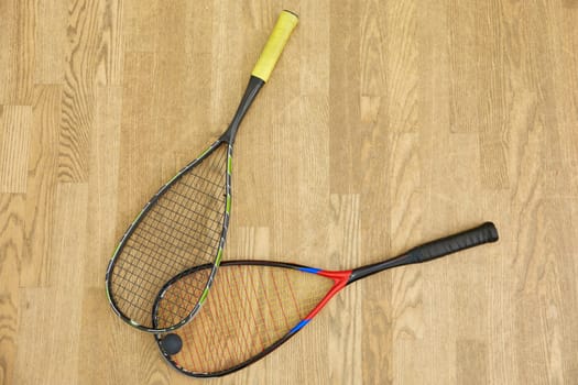 Closeup professional squash game racquet and ball training equipment on court floor top view