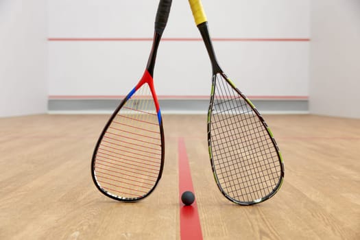 Closeup professional squash game racquet and ball training equipment on court floor top view