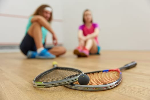 Sportspeople at recreational court. Closeup view on squash game training equipment