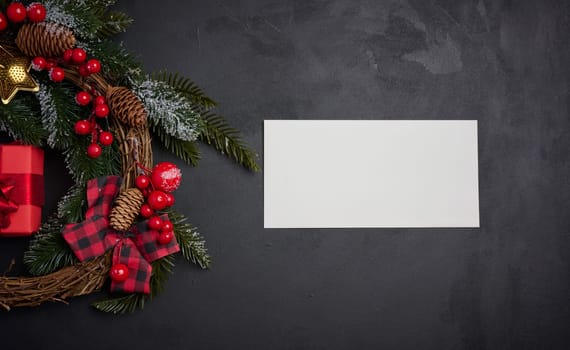 White envelope and Christmas wreath on a black background, top view
