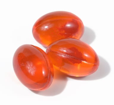 Orange capsules with fish oil on a white background, top view