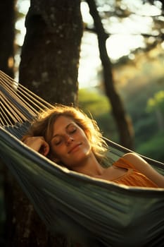 The girl swinging in the hammok on the seashore on the sunrise. beachtime.