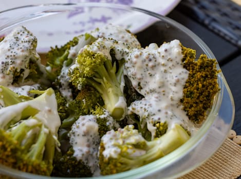 Healthy diet. Steamed broccoli topped with yogurt sauce