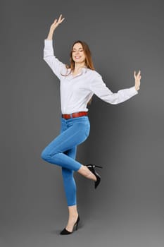 Joyful smiling woman balancing on one leg waving her arms