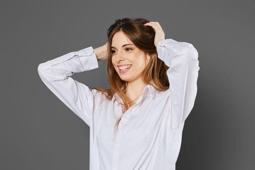 Happy woman clutching her head with both hands, looking to the side and smiling
