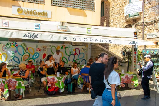 Sicily, Taormina, Italy - 28 September 2023. A street musician at a restaurant on the famous main street Corso umberto in Taormina. City views, facades, architecture.