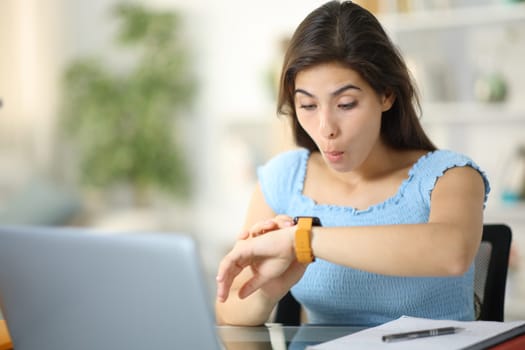 Surprised student checking smartwatch at home