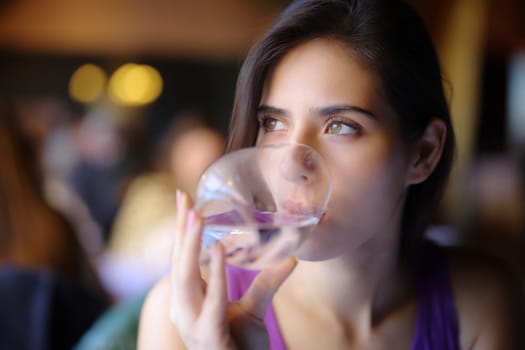Distracted woman drinking water in a restaurant