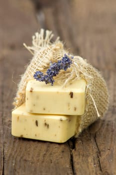 bar of natural soap with dried lavenderon wooden background