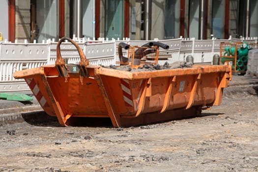 Container, orange skip for construction waste standing on the road, road construction work, construction site, Germany