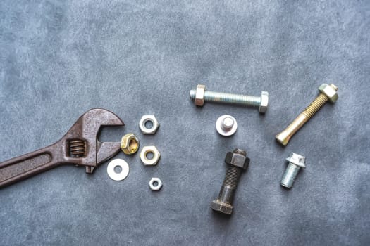 Wrench, hex bolt and hex nut on leather floor.